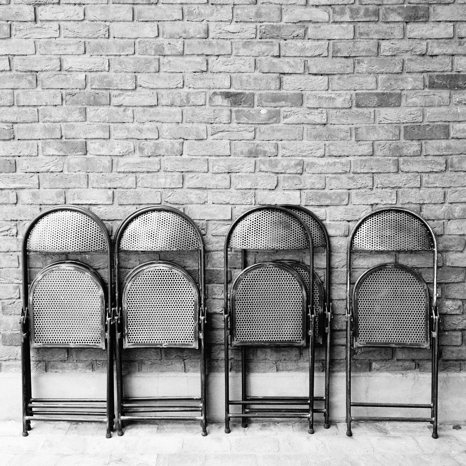 Chaises pliantes contre un mur de briques
